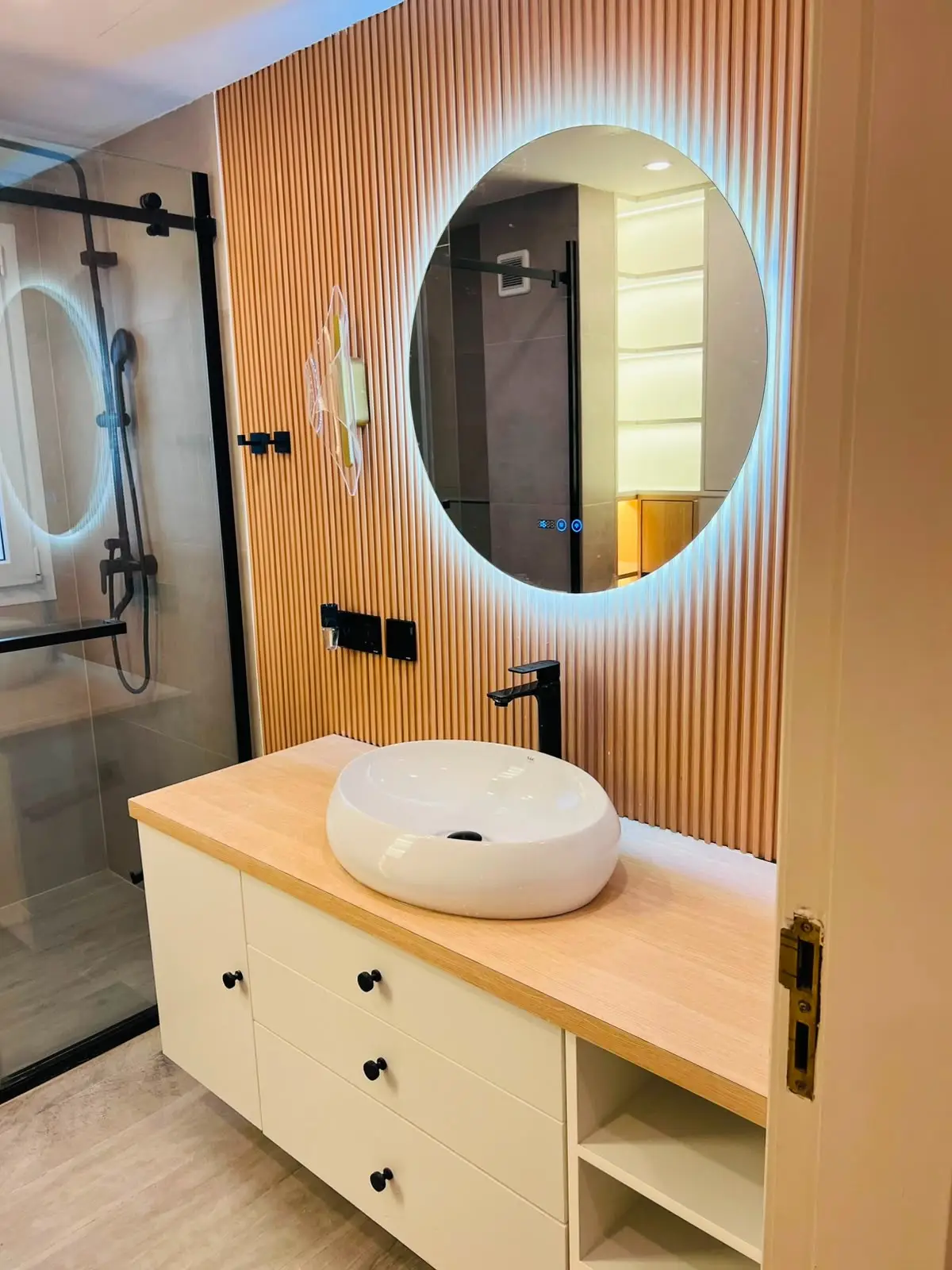 Completed bathroom with fitted vanity, illuminated mirror and walk-in shower